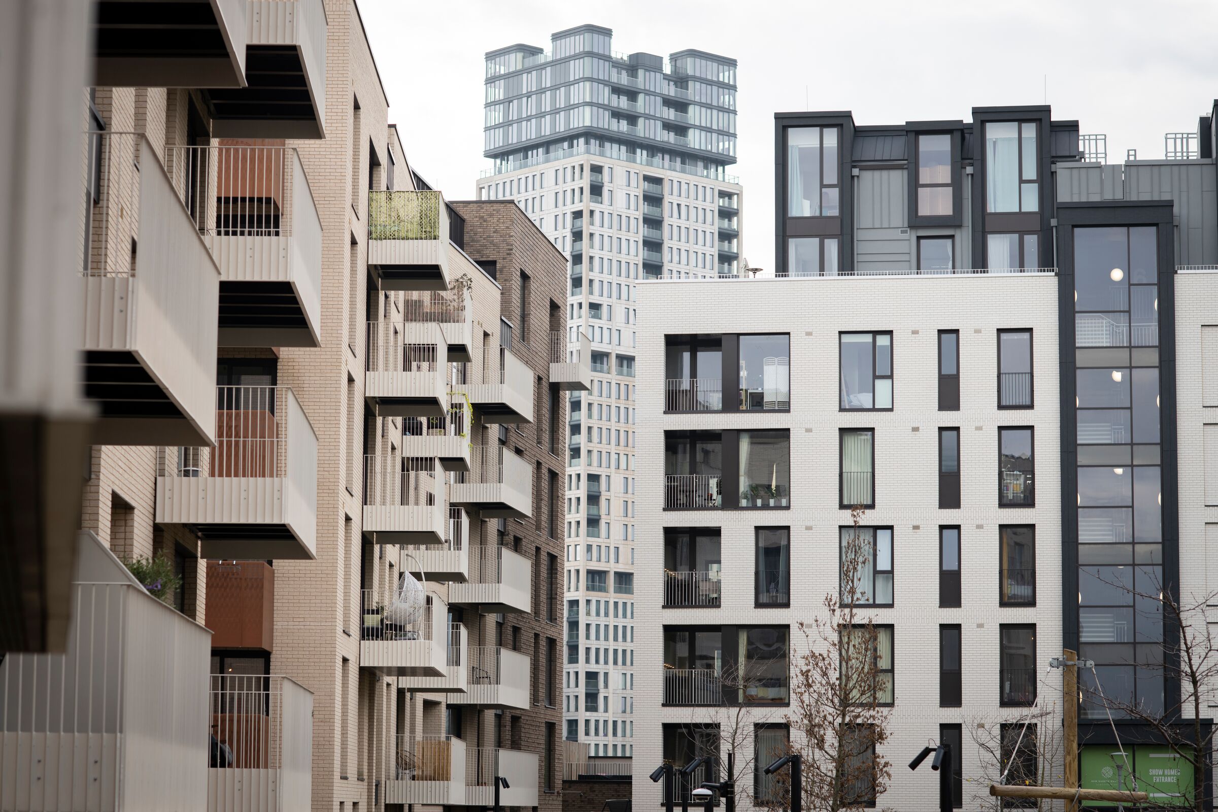 Modern black, white and tan blocks of flats, with square glass windows and balconies.