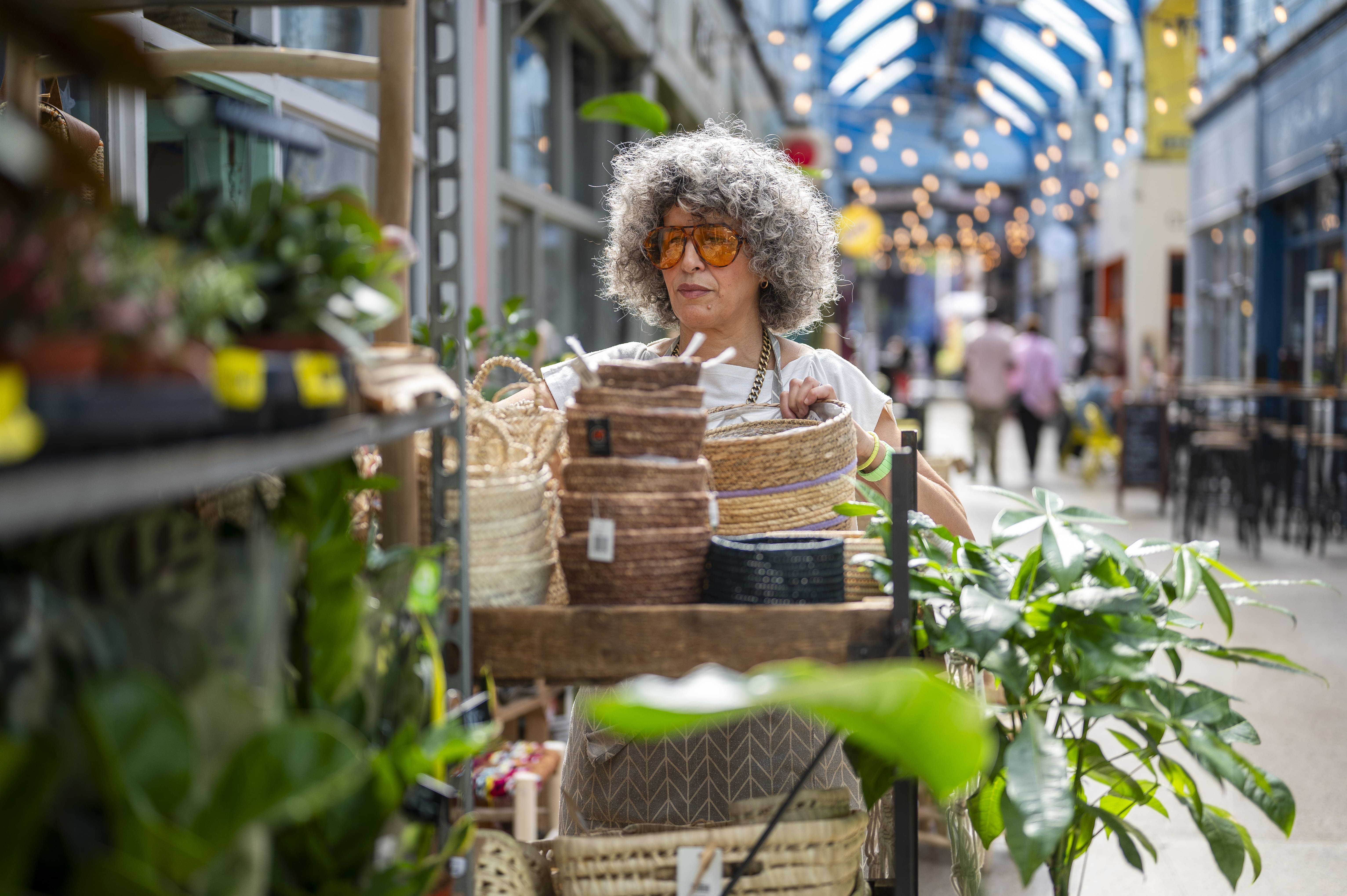 Woman browing baskets outside London shop