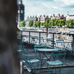 a table and chairs on a patio overlooking the river Thames