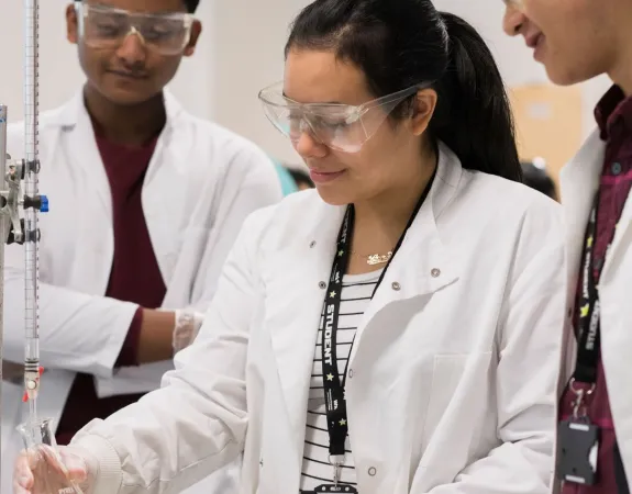 Smiling trainees in lab coats