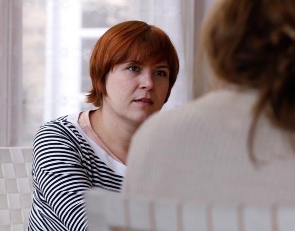 Two women sat in chairs having a conversation