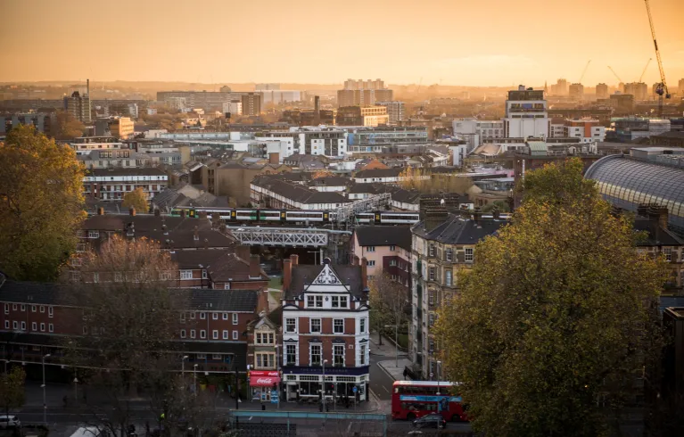 A view across London at sunset with a warm orange sky