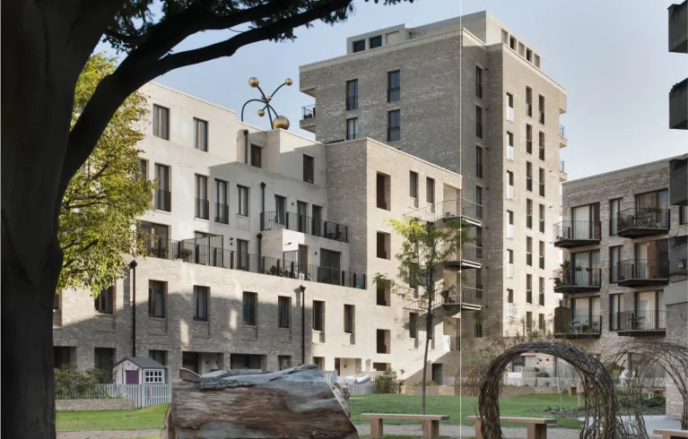 Image of a mock up building of flats with a tree and a bench in front