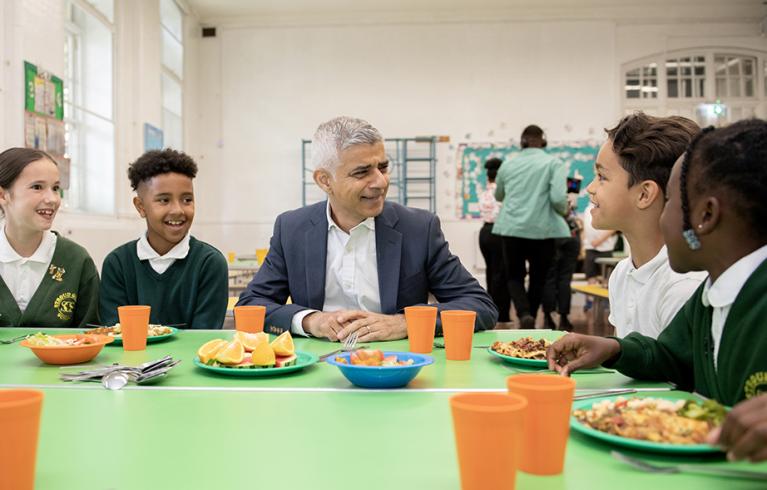 Mayor Sadiq Khan at a school table with four students eating lunch