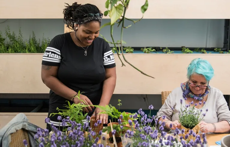 Photo showing two volunteers working in a plant shop in Dalston