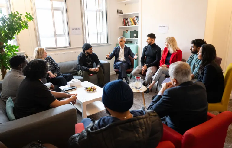 The mayor with community members talking in a circle.
