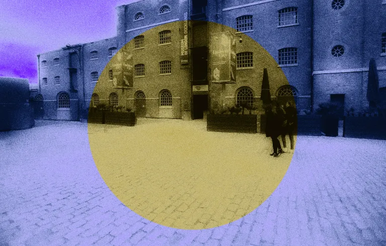 London Docklands public square photograph with a faded, grainy purple filter overlaid. A central yellow circle spotlights the location for a new memorial artwork.
