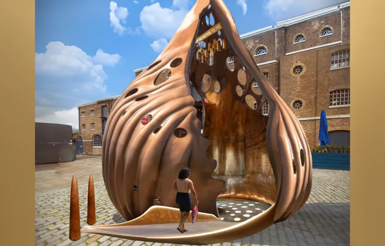 Computer-generated image with a traditional building in the background and a large, bronze colour sea shell, with a low ramp going into the centre, with a figure walking up the ramp. image with a traditional building in the background and a large, bronze colour sea shell, with a low ramp going into the centre, with a figure walking up the ramp.