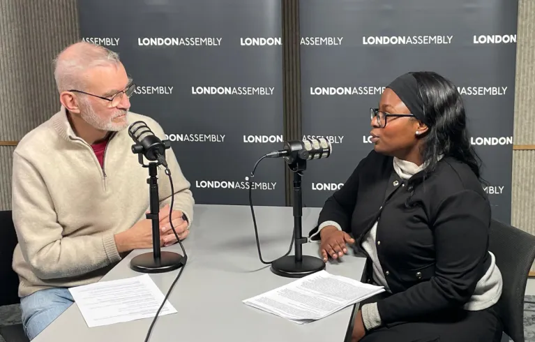 older man and young woman talking into microphones