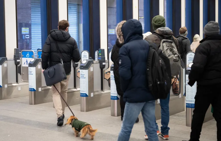 Tube customers walk towards ticket barriers at an underground station