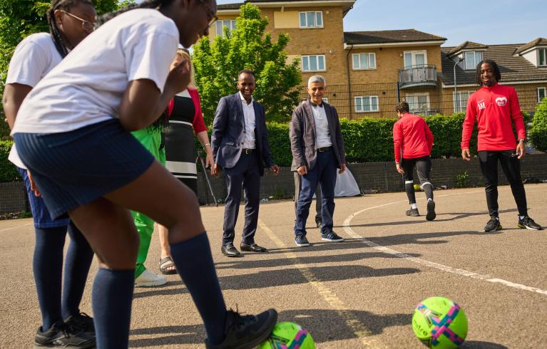 Young people play football in a group mentoring activity.