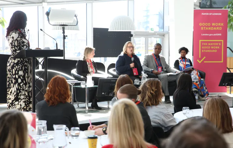 People on a stage on a panel with audience members