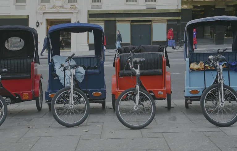 4 pedicabs on street.