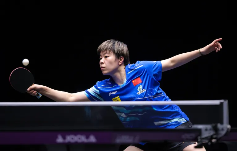 Man in blue shirt playing table tennis