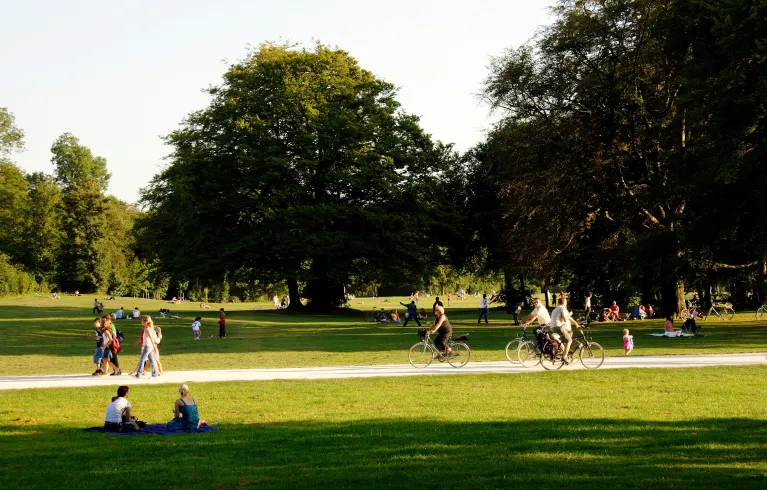 People cycling and relaxing in a park on a sunny day