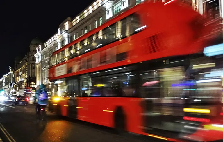 A bus on a London road at night