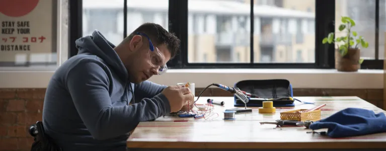 Man sitting at a desk and working on electrical systems