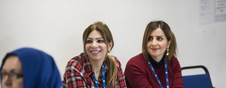 Two women listening to lecture in class