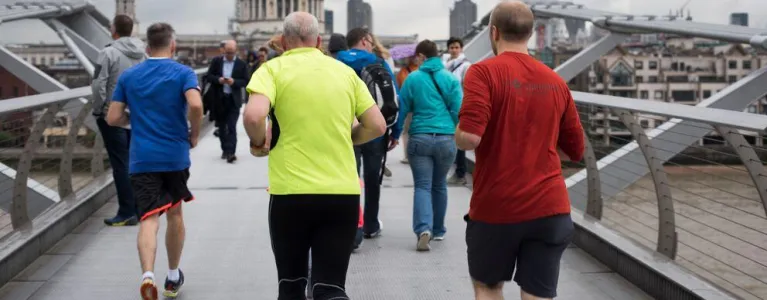 Group of people jogging over the Millennium Bridge