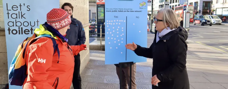 Caroline Russell speaks about public toilets on the tube network with a person on a London street