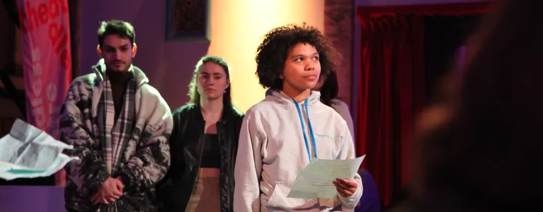 Young people from National Youth Theatre and Queen Mary’s University of London performing on stage, sharing the creative energy of Rewire events.