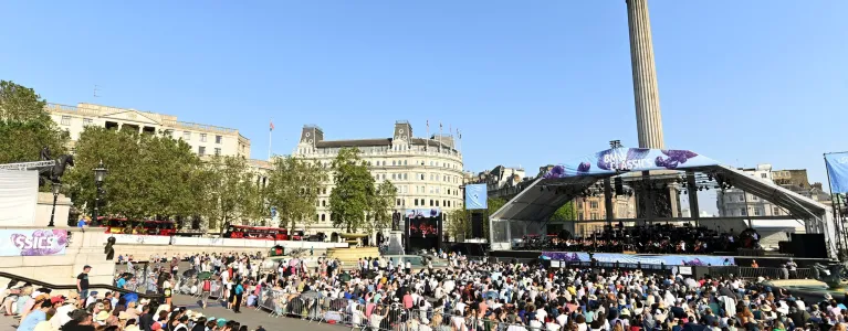 People sitting at an outside concert on Trafalgar square