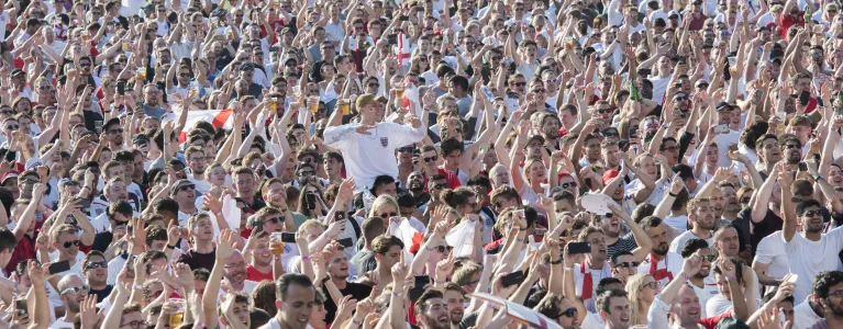 Crowds of fans with England shirts on at a football match