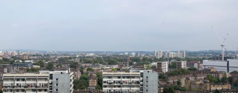 Skyline view across London with tower blocks and housing estates.