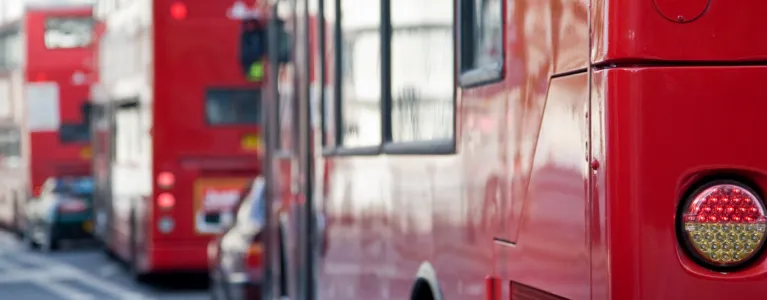 Three red London buses in a queue