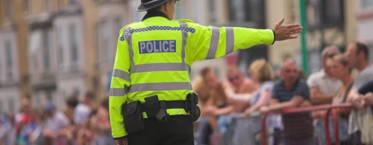 police officer in front of people protesting