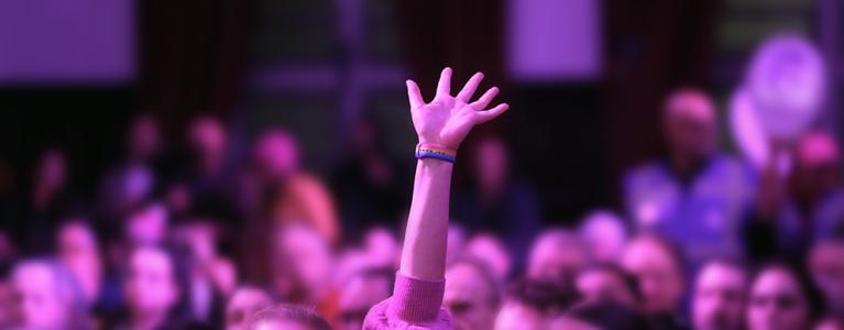 Image of a hand raised in the audience