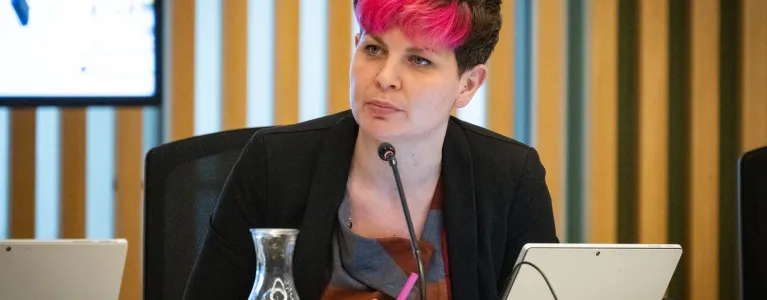 Zoë Garbett speaks at Mayor's Question Time, seated in the City Hall Chamber.