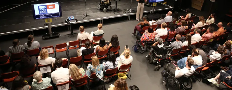 Room of people listening to a speaker