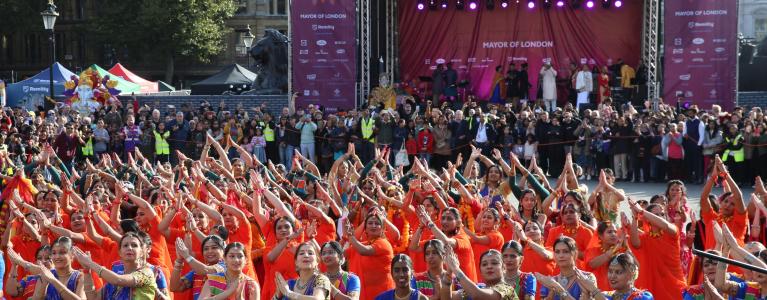 Group of dancers in front of the main stage dancing tradition South Asian dance and in traditional South Asian attire.