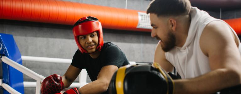 Young person and their mentor take a break during a summer holiday activity at a boxing club in London.
