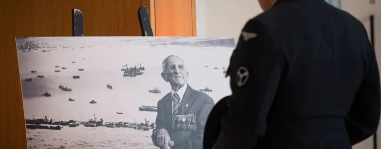 Man looking at a portrait of British veteran
