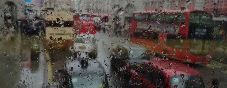 rainy window of car with view of traffic.