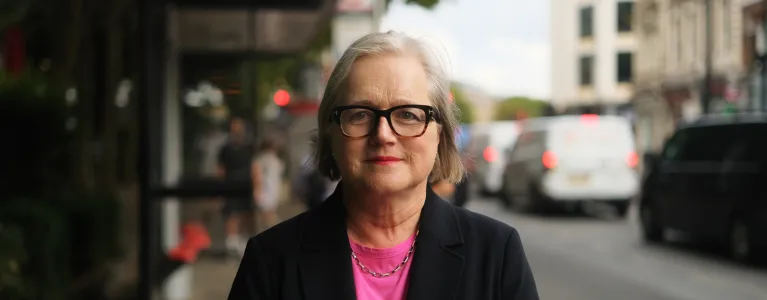 Caroline Russell AM standing in front of a bus stop