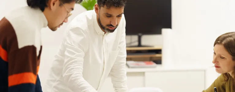 Image of 3 people looking at plans on a table
