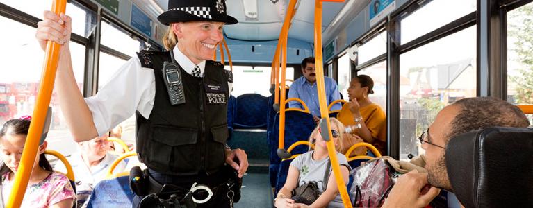 Police officer speaks with member of the public on a bus