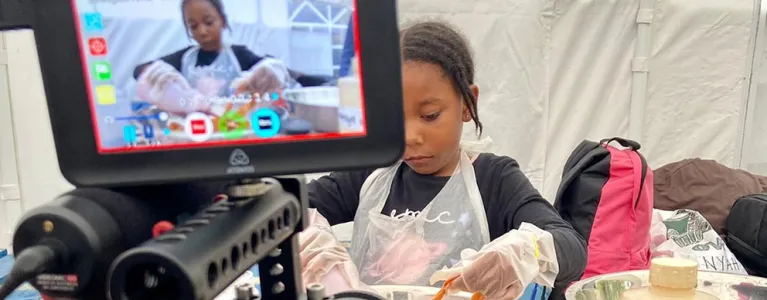 A young girl filming her baking during the Festival of Ideas