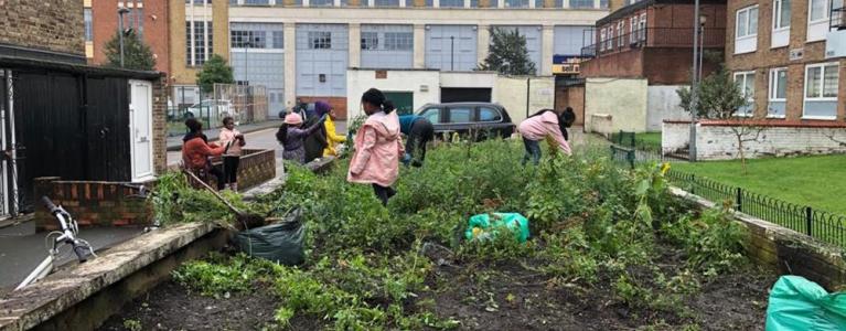 children gardening next to a tower block