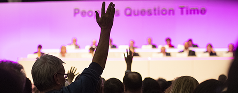 People from the audience raising their hands at People's Question Time