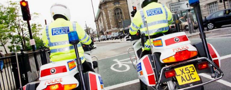 Policemen on motorbike waiting at red light. 	© Martin Breschinski