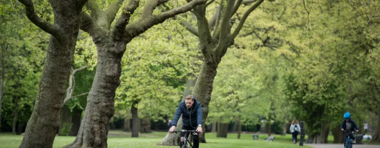 Person cycling through park