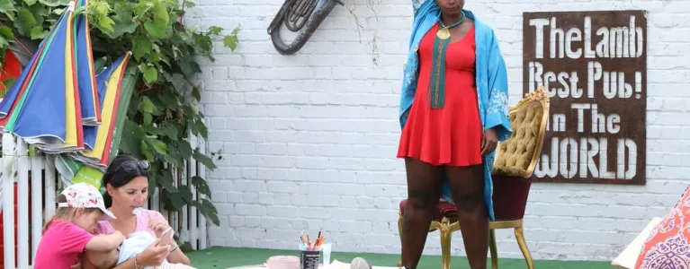 Woman stands on stage in a pub garden performing