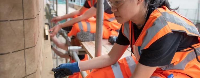 Three people work from scaffolding on Ladywell's SelfBuild Community space