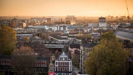 A view across London at sunset with a warm orange sky