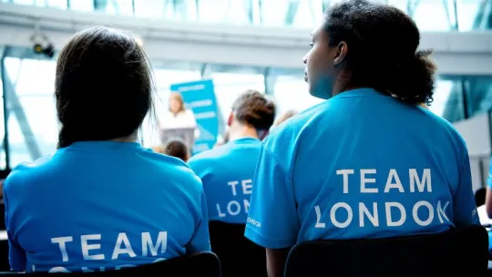 Two members of Team London sitting at a conference