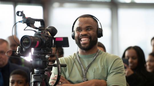 Person filming at Young People's Action Group event